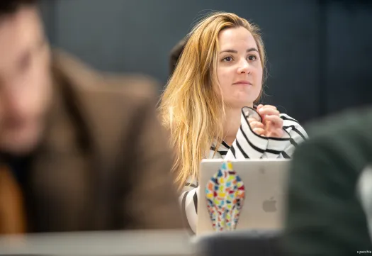 Une etudiante concentrée en classe, regardant devant elle.