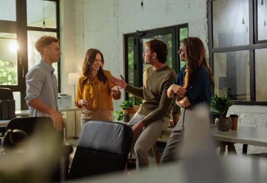 des collaborateurs échangent en souriant