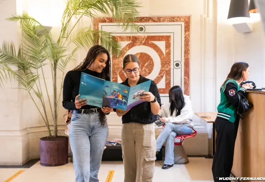 deux étudiantes regardant la brochure PSTC