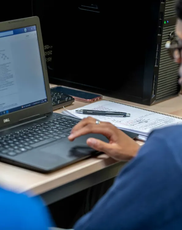 Étudiant travaillant sur un ordinateur portable dans une salle informatique.
