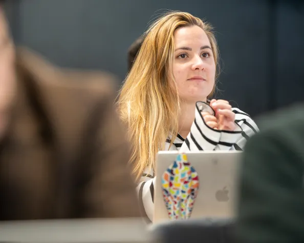 Une etudiante concentrée en classe, regardant devant elle.