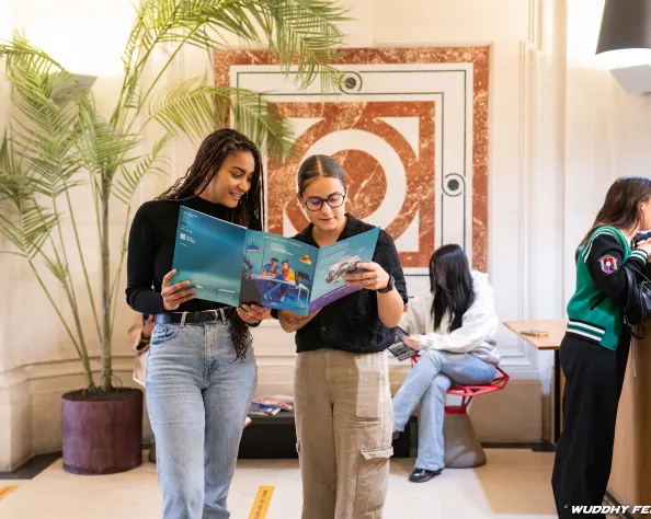 deux étudiantes regardant la brochure PSTC